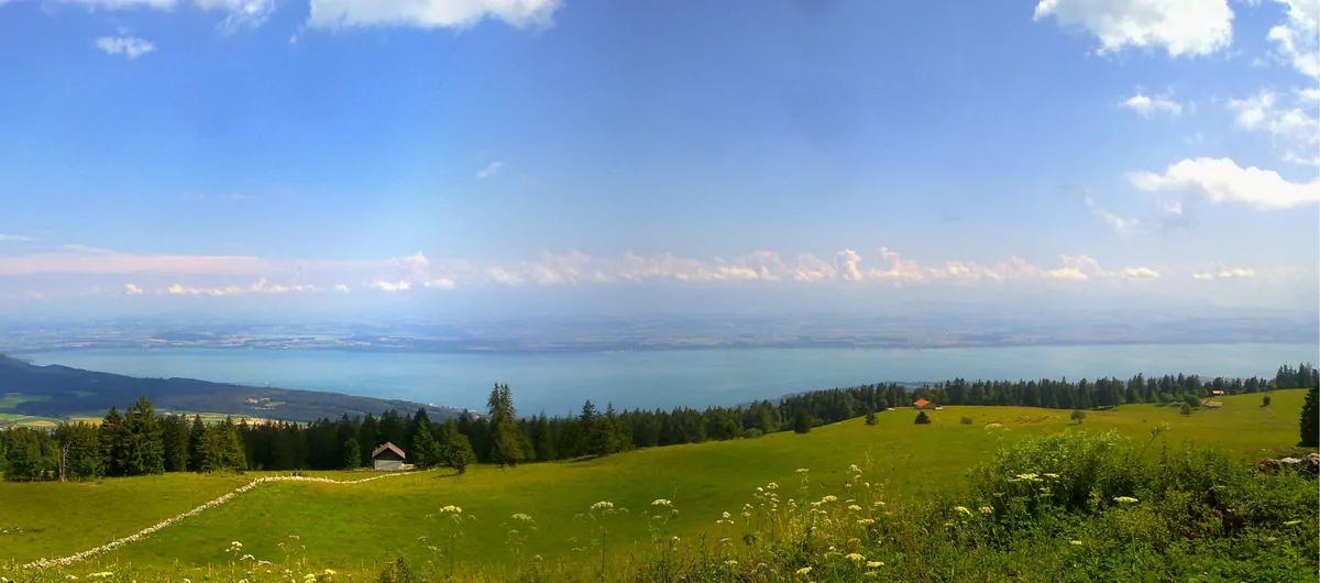 Panorama sur le lac de Neuchâtel, les pâturages et les crêtes du Jura depuis le Mont Racine.